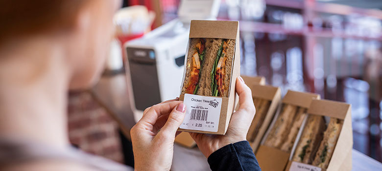 Food label being applied to sandwich in deli