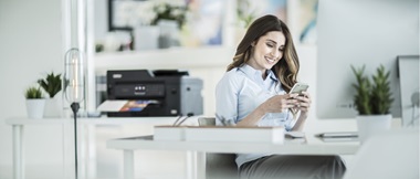 A lady printing a document from a smartphone in a home office environment