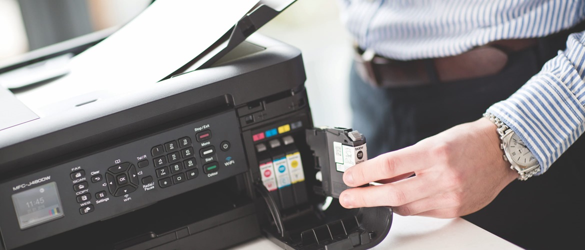 A man changing an ink cartridge in a Brother inkjet printer