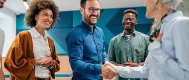 Smiling colleagues and business partners smiling and shaking hands after a meeting