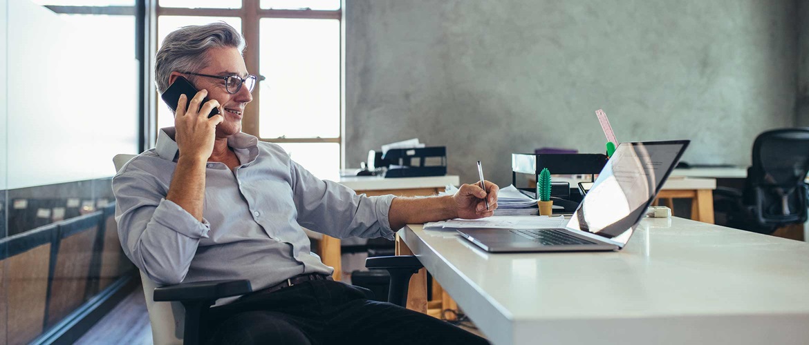 IT manager sitting at desk in front of laptop