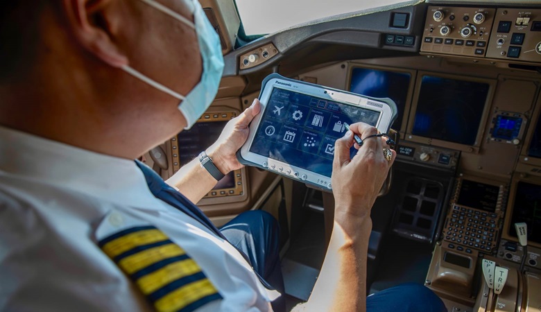 A male pilot using an eTechLog8 tablet to log safety checks while sitting in an aircraft cockpit