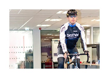 Phil Jones cycling through the Brother UK offices