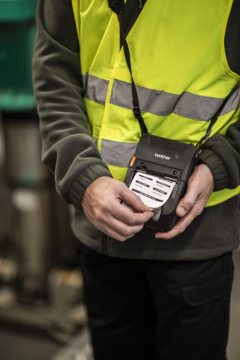 RJ-3200 mobile printer being held by a man in a high visibility jacket whilst he prints a series of labels 